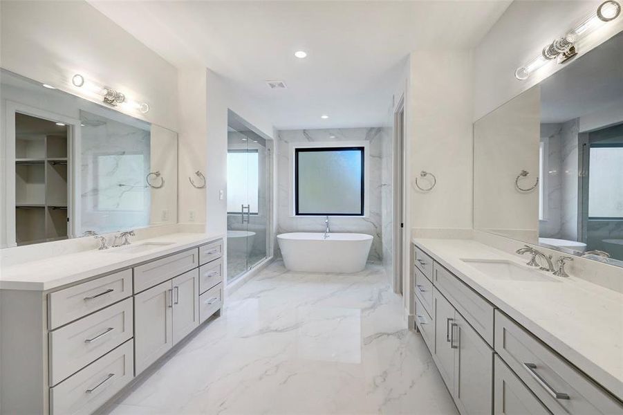 SAMPLE - Freestanding soaking tub and opaque window western exposure for natural light. Beautifully appointed primary bathroom with also features large walk-in shower, two walk-in closets and two generous vanities. Floors and walls are ceramic porcelain tile. Vanity counters are quartz.