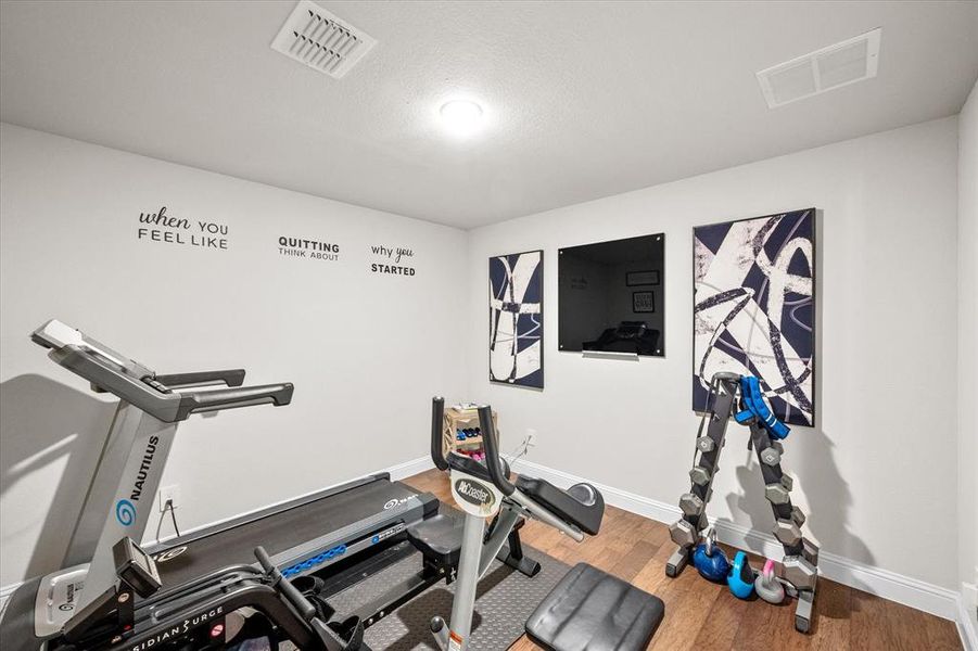 Workout area featuring a textured ceiling and wood-type flooring