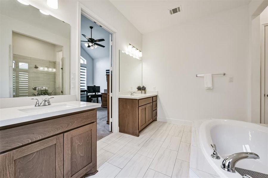 The primary bathroom features tile floors, dual sinks, and separate soaking tub.