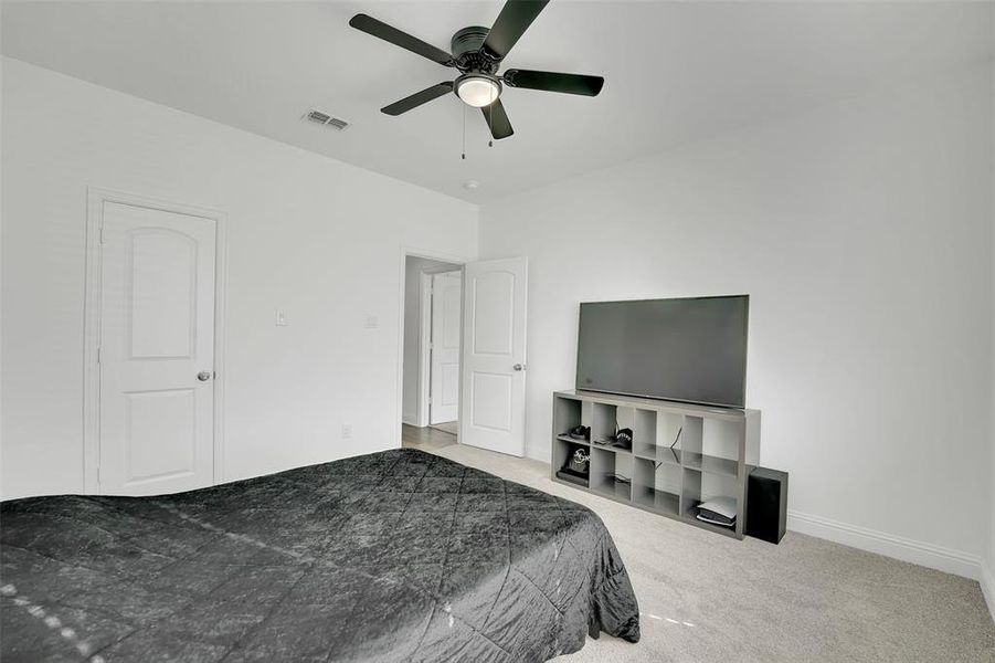 Bedroom with light colored carpet and ceiling fan