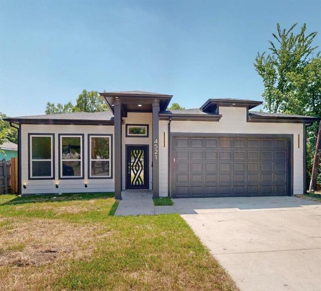 View of front of home with a garage and a front yard