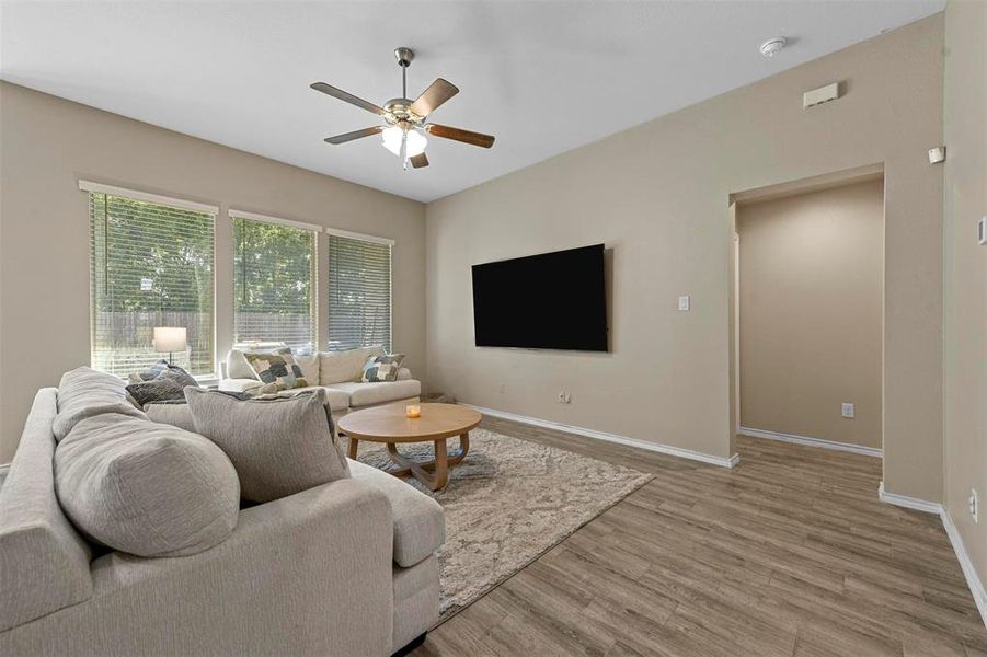 Living room with light hardwood / wood-style flooring and ceiling fan