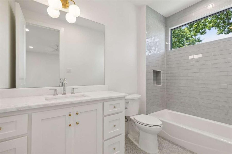 Full bathroom with vanity, toilet, and tiled shower / bath