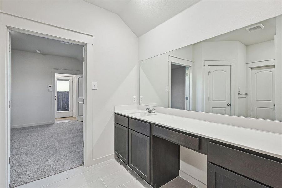 Bathroom with lofted ceiling, vanity, and tile patterned floors