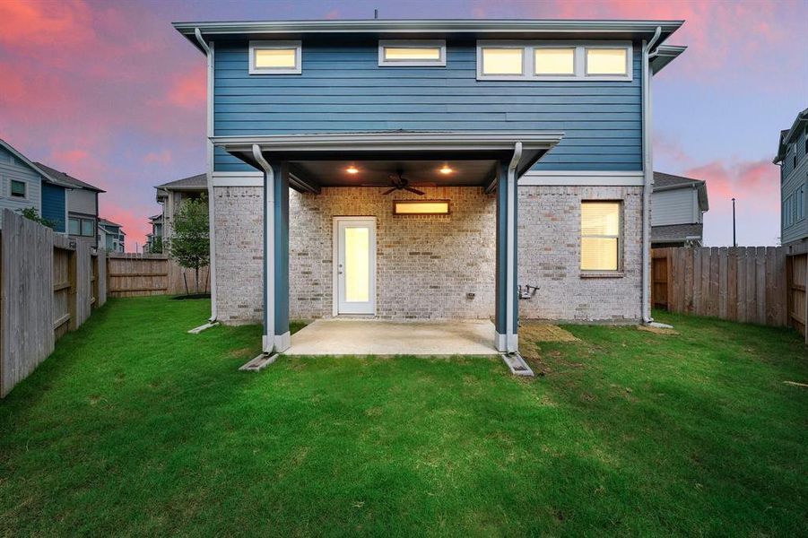 This beautiful sunset shot of your covered back patio showcases the space and wonderful size of this backyard perfect for setting up outdoor seating or letting the kids run wild!