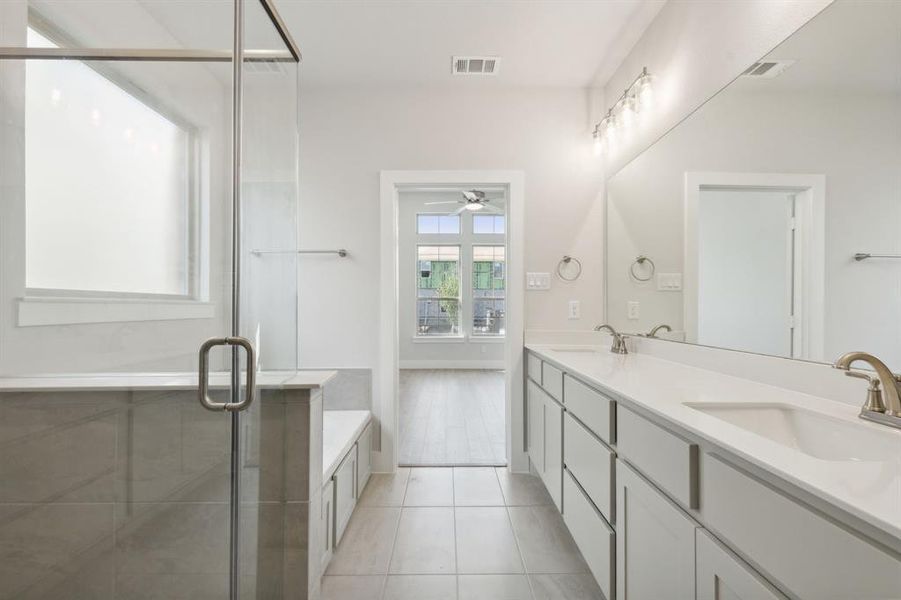 Bathroom featuring tile patterned flooring, vanity, ceiling fan, and independent shower and bath