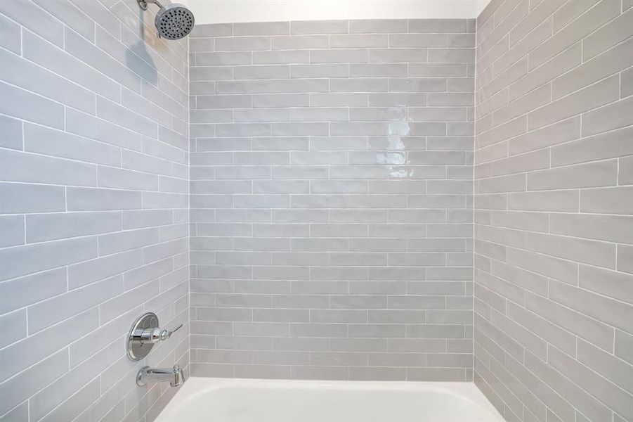 Modern bathroom with sleek subway tiles and a luxurious rainfall showerhead, creating a serene spa-like experience.