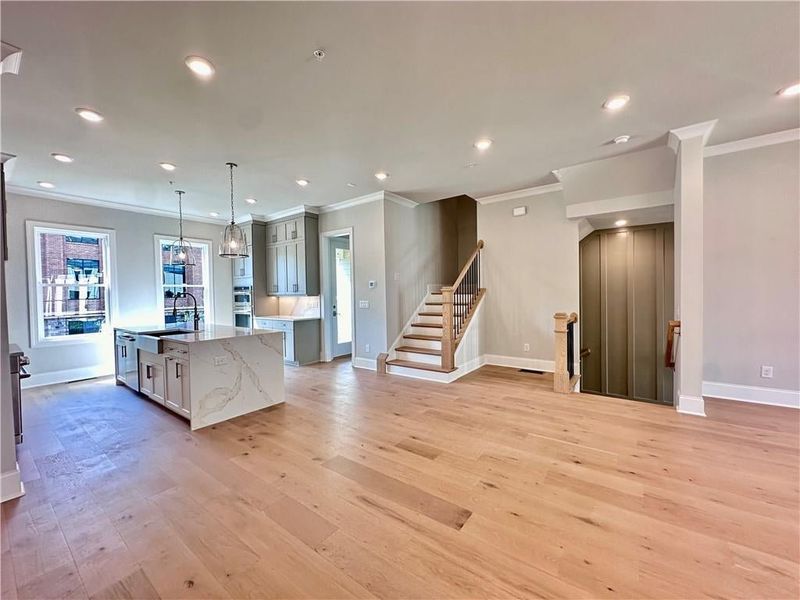 Kitchen is ideally situated in the back of the showcasing gray cabinetry to the ceiling