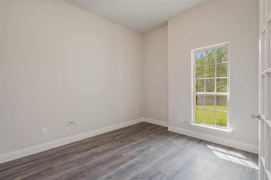 Spare room with dark wood-type flooring