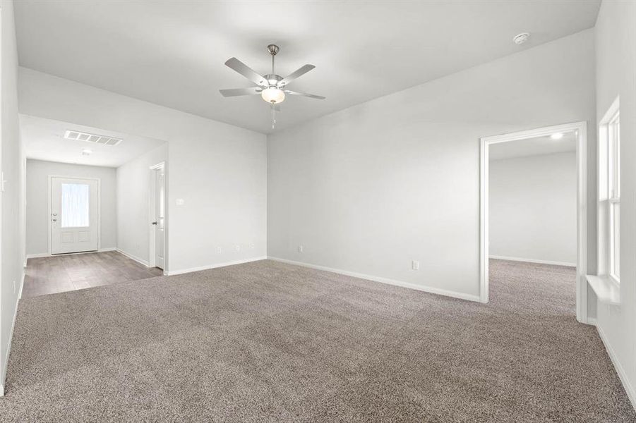 Empty room featuring ceiling fan and carpet flooring