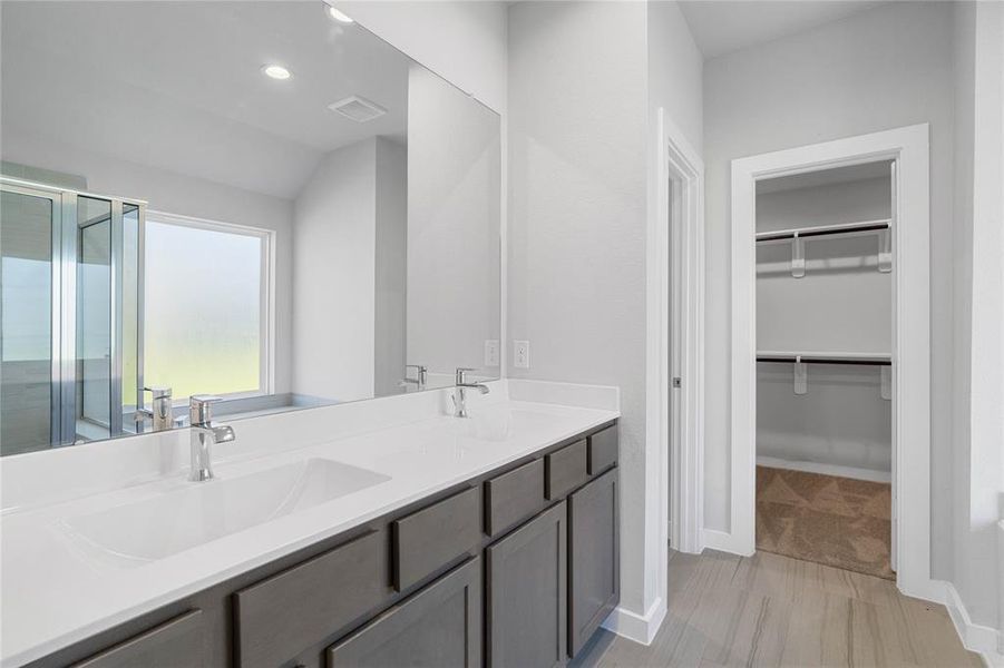 This primary bathroom is definitely move-in ready! Featuring grey stained cabinets with light countertops, spacious walk-in closet with shelving, high ceilings, custom paint, sleek and modern finishes.