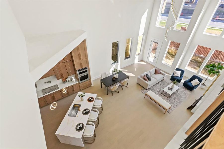 Living room with a towering ceiling, light colored carpet, and a wealth of natural light