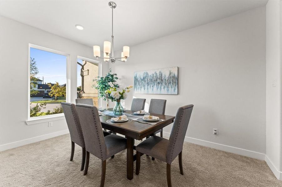 The dining area boasts large windows with a neighborhood view and a graceful chandelier, creating an inviting atmosphere.