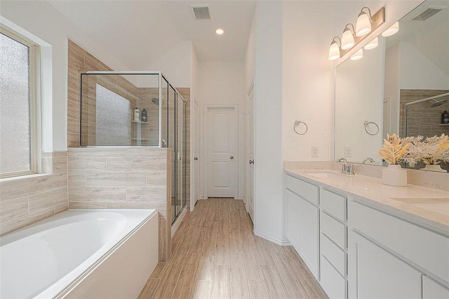 This bathroom offers a spa-like experience with a deep soaking tub and a separate walk-in shower.