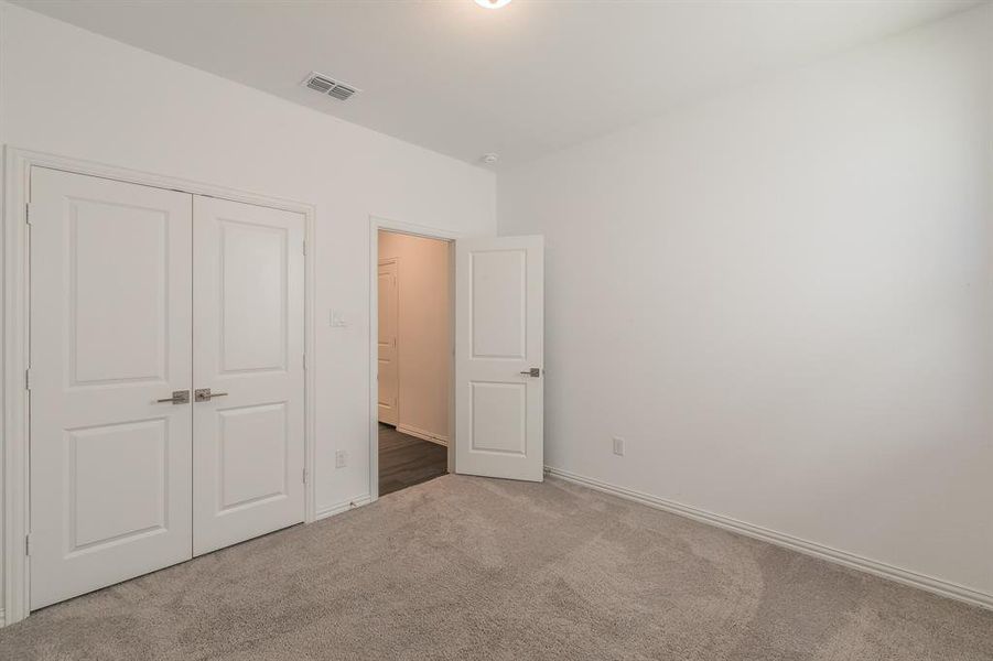 Unfurnished bedroom featuring carpet and a closet