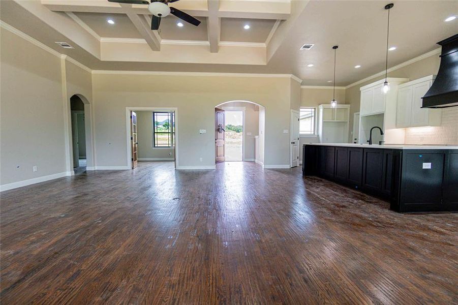 Kitchen with hardwood / wood-style flooring, custom range hood, coffered ceiling, and ornamental molding