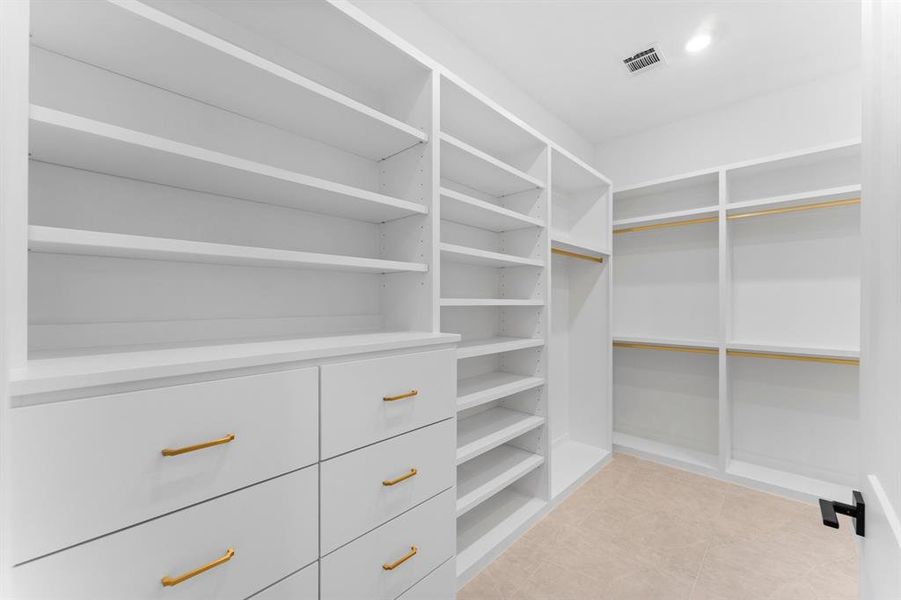 Step into your dream walk-in closet.This expansive space features custom-built shelving and abundant hanging space, ensuring everything from shoes to accessories has its perfect spot.