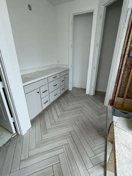 Main bath with herringbone tile flooring