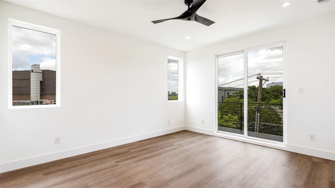 Unfurnished room with a healthy amount of sunlight, hardwood / wood-style floors, and ceiling fan