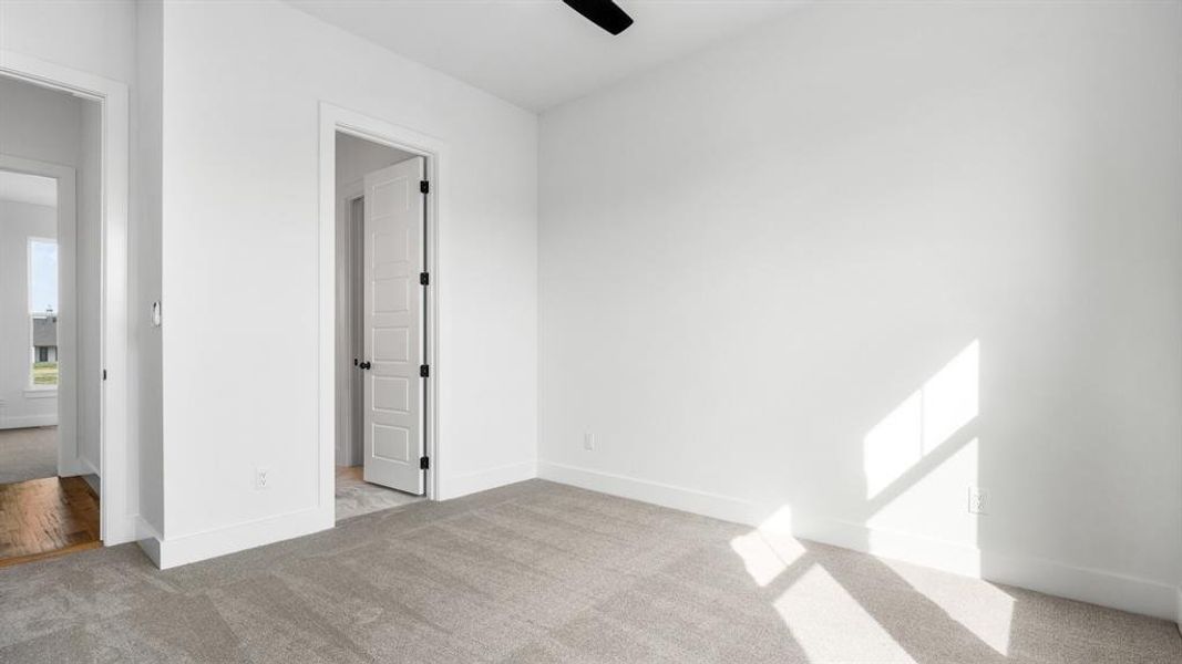 Unfurnished bedroom with ceiling fan and light colored carpet