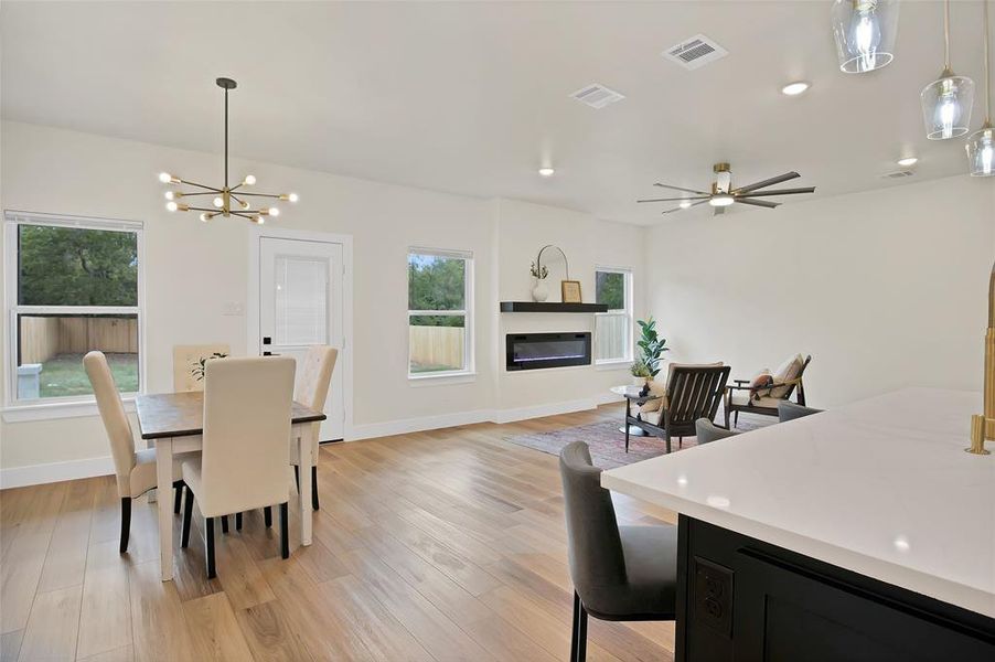 Dining room featuring light wood-type flooring and ceiling fan with notable chandelier