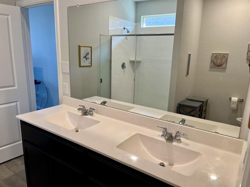 Bathroom with double vanity and a shower with door