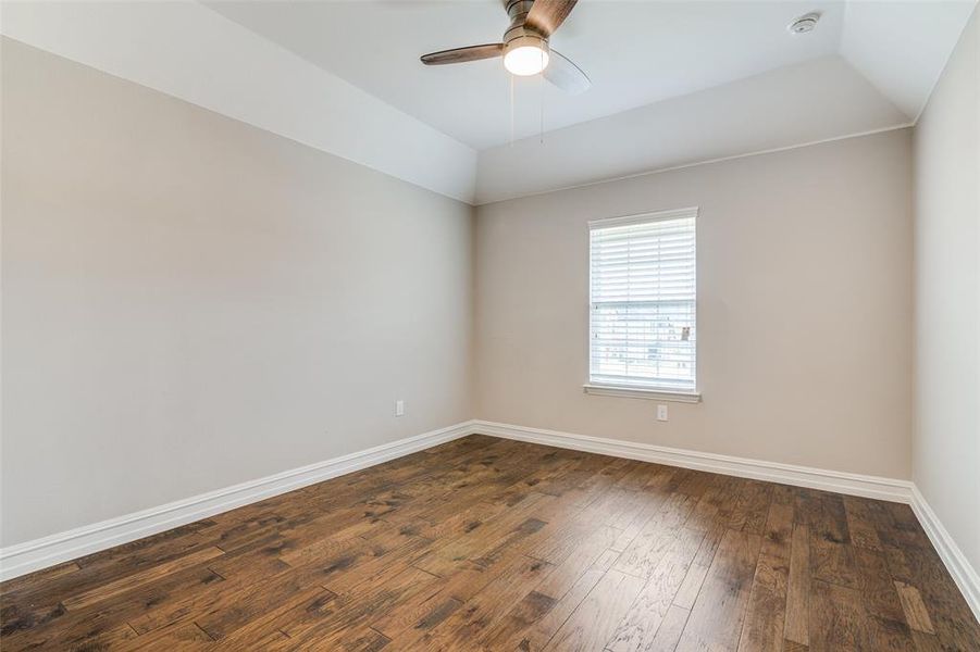 Unfurnished room with dark hardwood / wood-style flooring, ceiling fan, and lofted ceiling