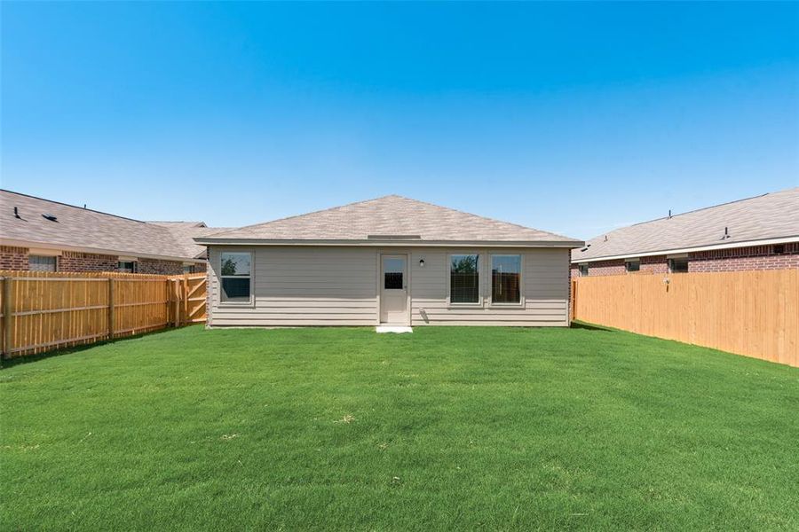 Rear view of house featuring a lawn