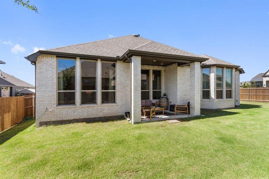 Rear view of property featuring a yard and a patio area