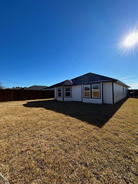 Rear view of house featuring sodded yard