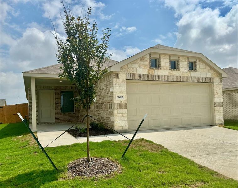 View of front facade featuring a front yard and a garage