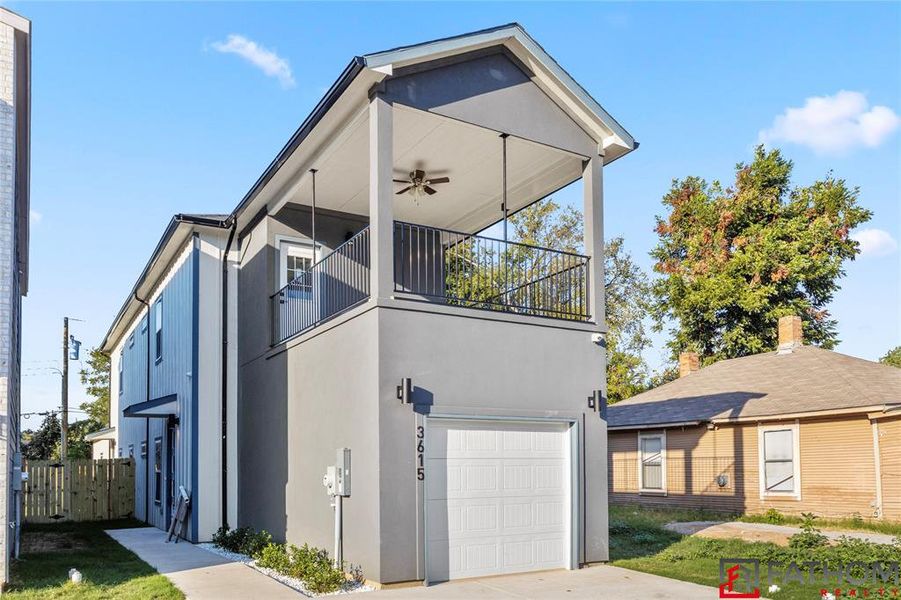 View of front of house with a garage, a balcony, and ceiling fan