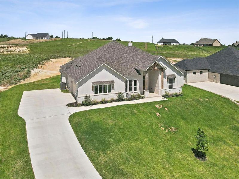 View of front of property with a garage and a front lawn