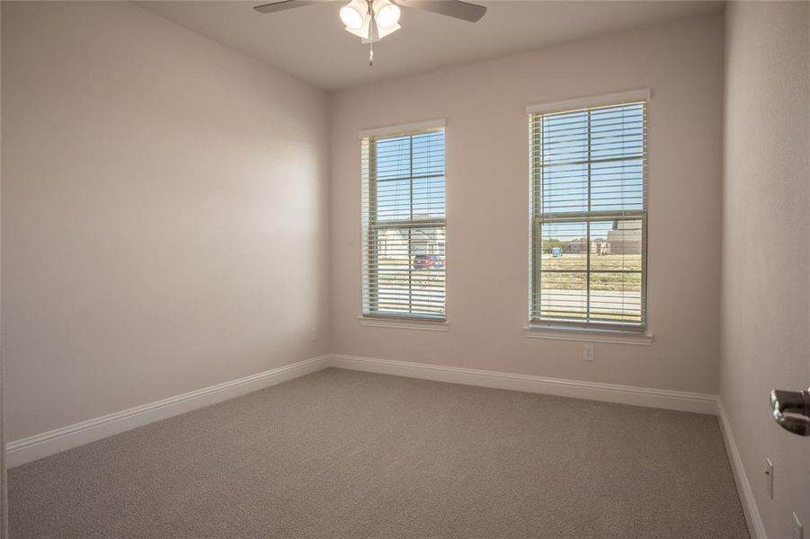 Carpeted empty room featuring ceiling fan