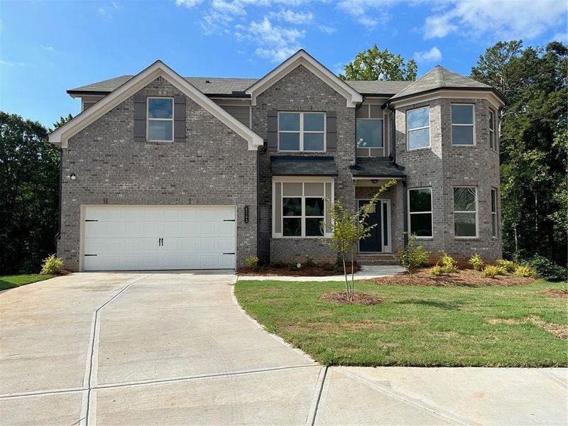 View of front of property with a front yard and a garage