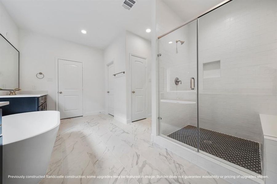 The bathroom's smart configuration provides access to one of two primary closets, a discreet water closet with a private commode, and a separate linen closet, contributing to the home's abundant storage options.