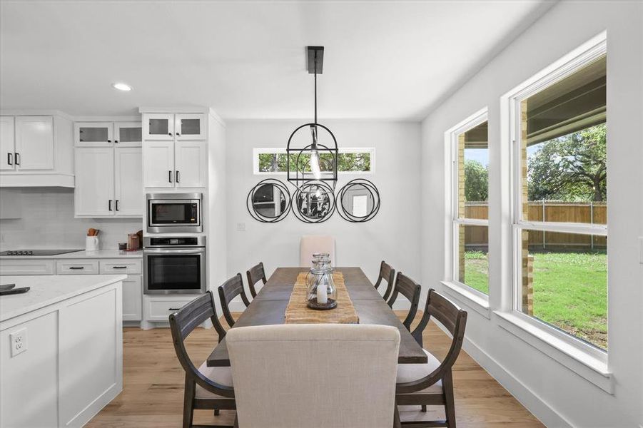 Dining room with light hardwood / wood-style flooring and a chandelier