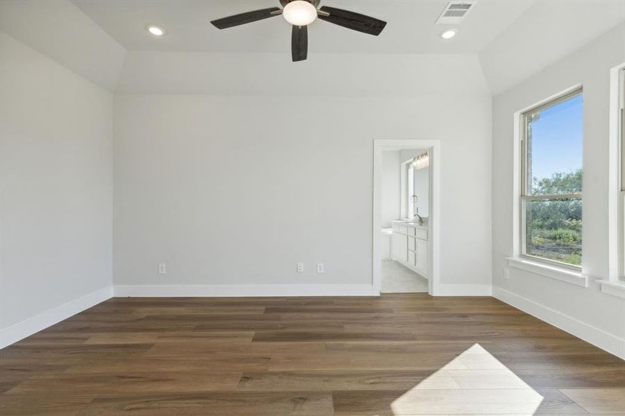 Unfurnished room with lofted ceiling, ceiling fan, and dark hardwood / wood-style flooring