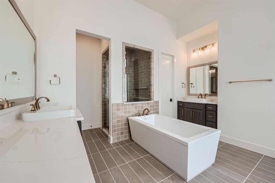 Bathroom with tile patterned flooring, vanity, and shower with separate bathtub