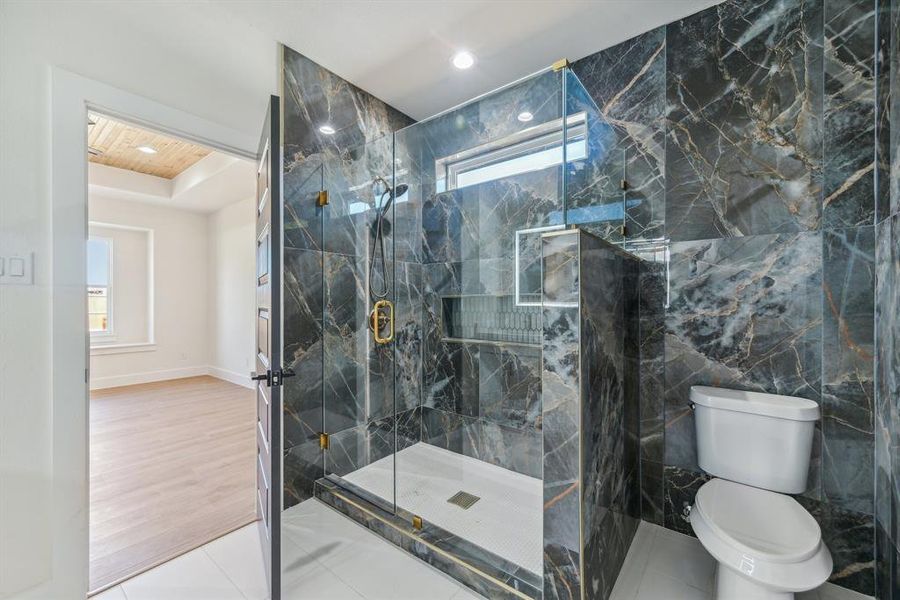 Bathroom with walk in shower, hardwood / wood-style floors, tile walls, and toilet