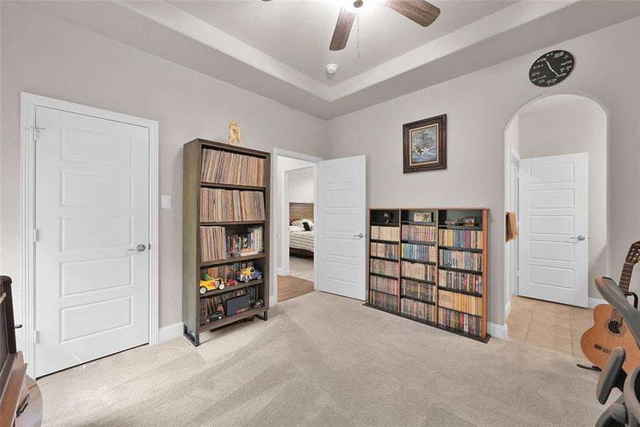 secondary bedroom located at the back of the home with walk-in closet, tray ceiling, and private vanity