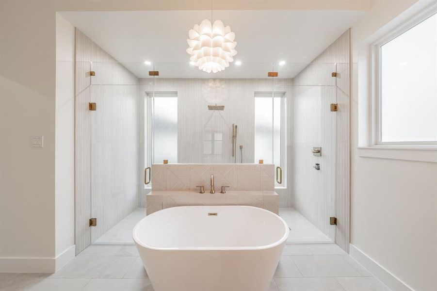 Bathroom with tile flooring, a chandelier, and plus walk in shower