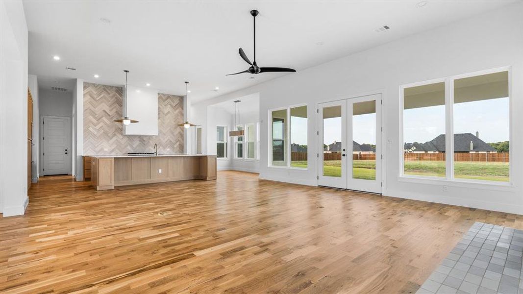 Unfurnished living room with ceiling fan and light wood-type flooring