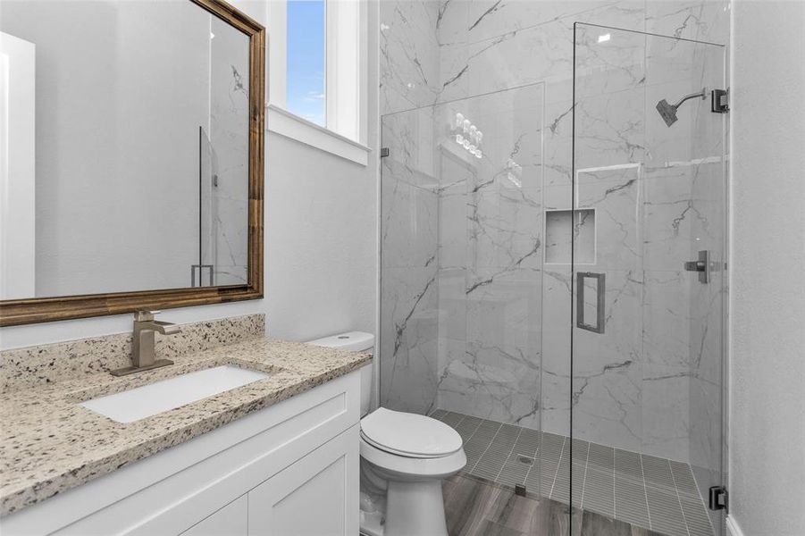 Bathroom #4. All Secondary Bathrooms offer walk-in showers with frameless glass and large inset storage and the same clean modern finishings used throughout the home, along with Delta sinks, faucets and shower shower finishings.