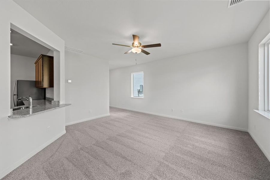 Living room with ceiling fan and light colored carpet