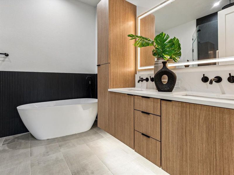 Bathroom featuring vanity, tile patterned floors, and a tub