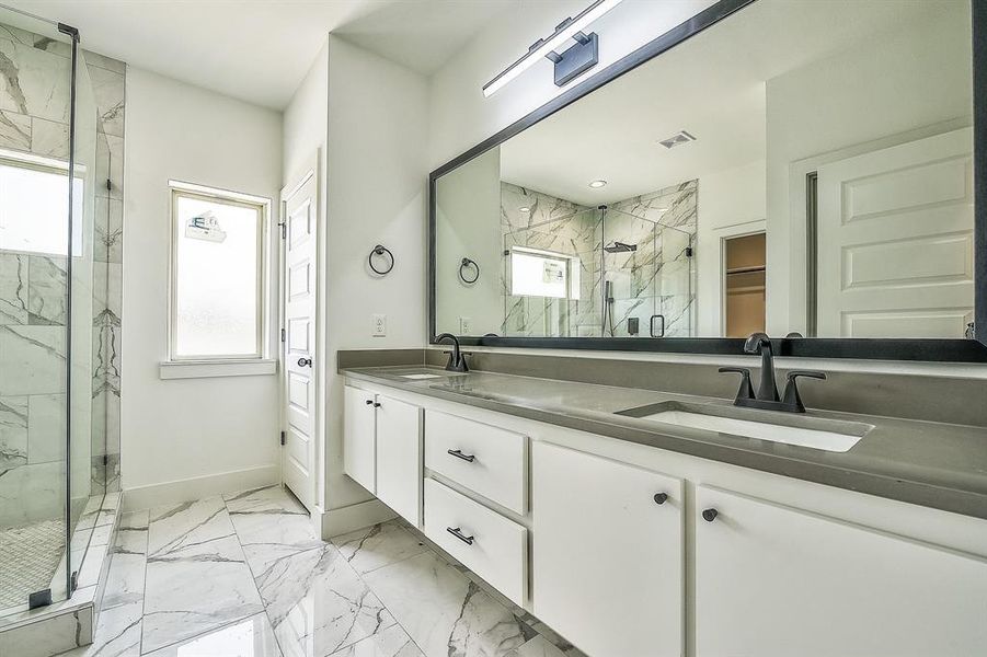 Bathroom with a wealth of natural light, vanity, and a shower with shower door