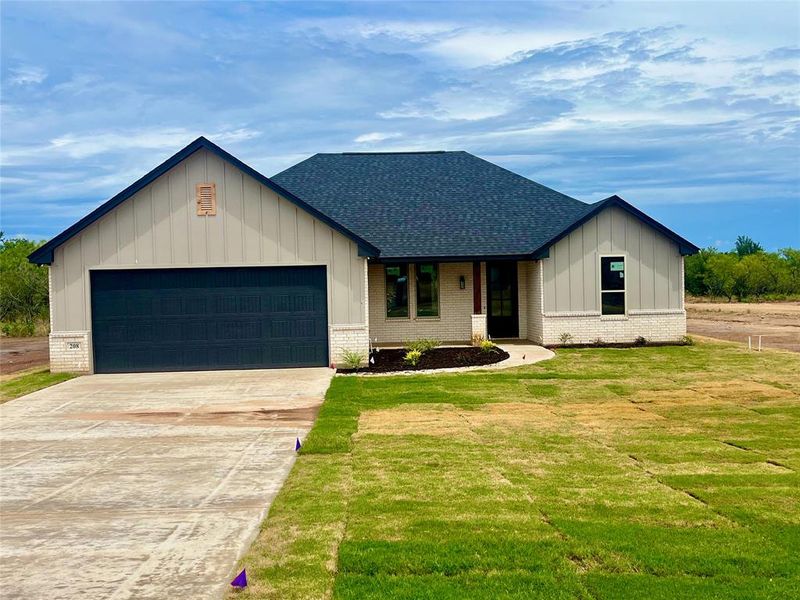 View of front of house with a garage and a front yard