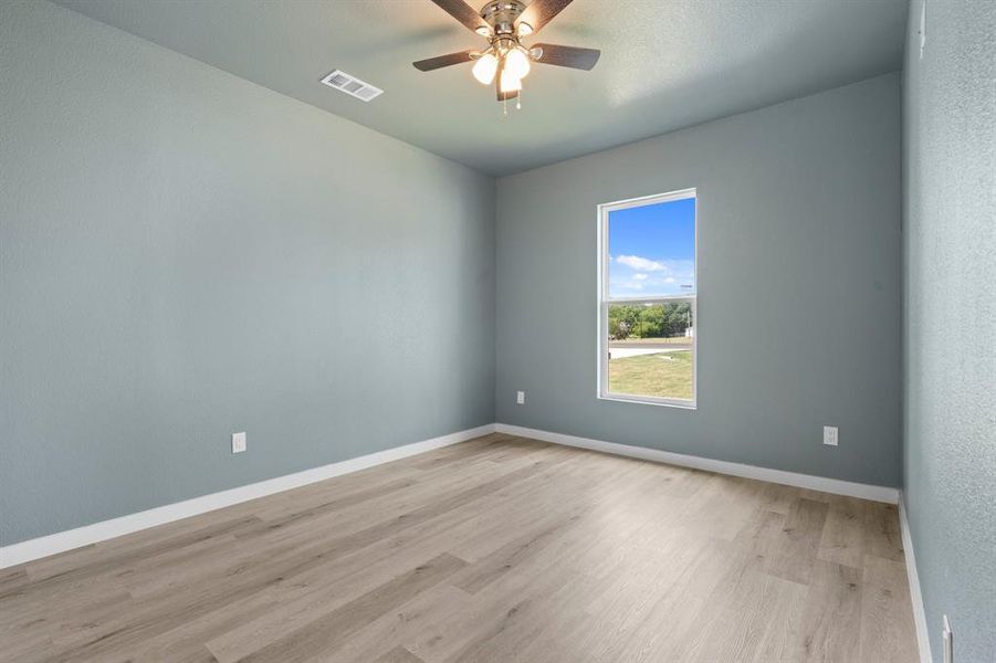 Empty room with ceiling fan and light hardwood / wood-style floors