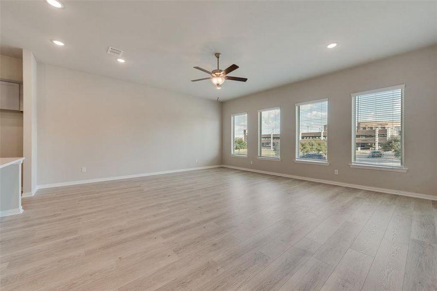 Unfurnished living room with ceiling fan and light hardwood / wood-style floors